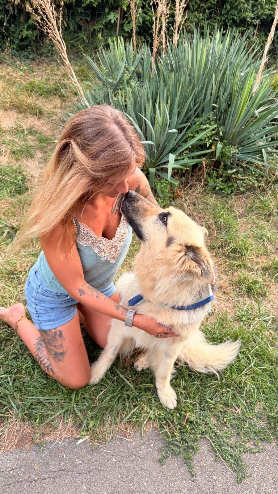 Pollyanna, le visage contre le museau de son chien.