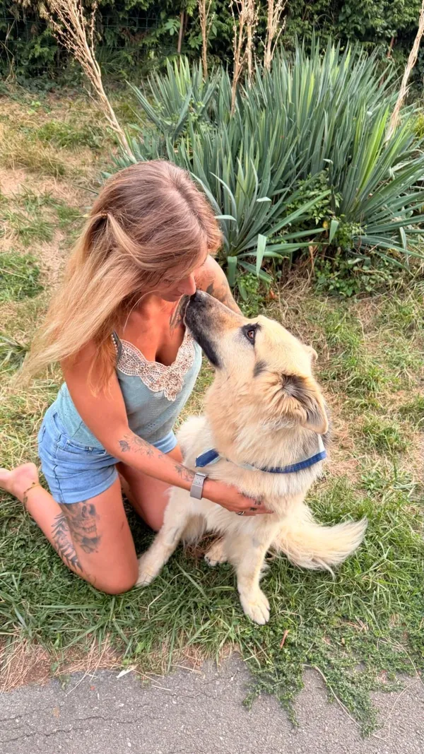 Pollyanna, le visage contre le museau de son chien.