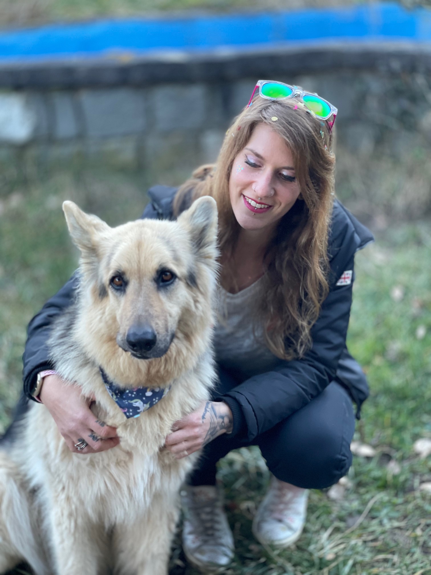 Pollyanna accroupie auprès d’un berger allemand